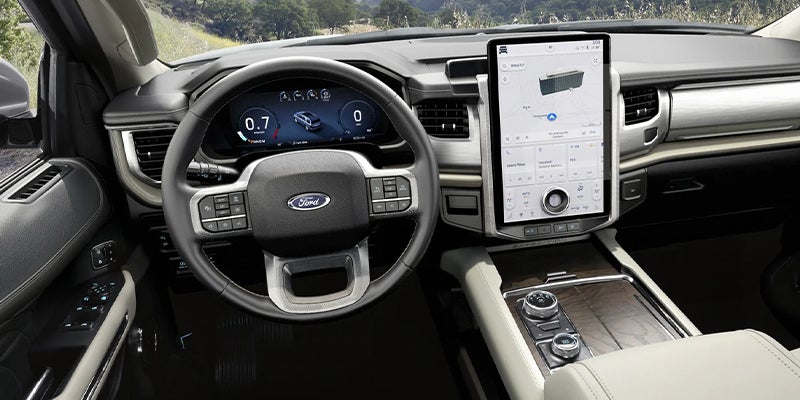 Interior of a modern SUV with a large central touchscreen, digital instrument cluster, and a Ford steering wheel.